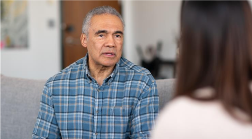 Bilde av en mann i samtale med en person