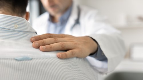Bilde av helsepersonell som holder en hånd på skulderen til en person