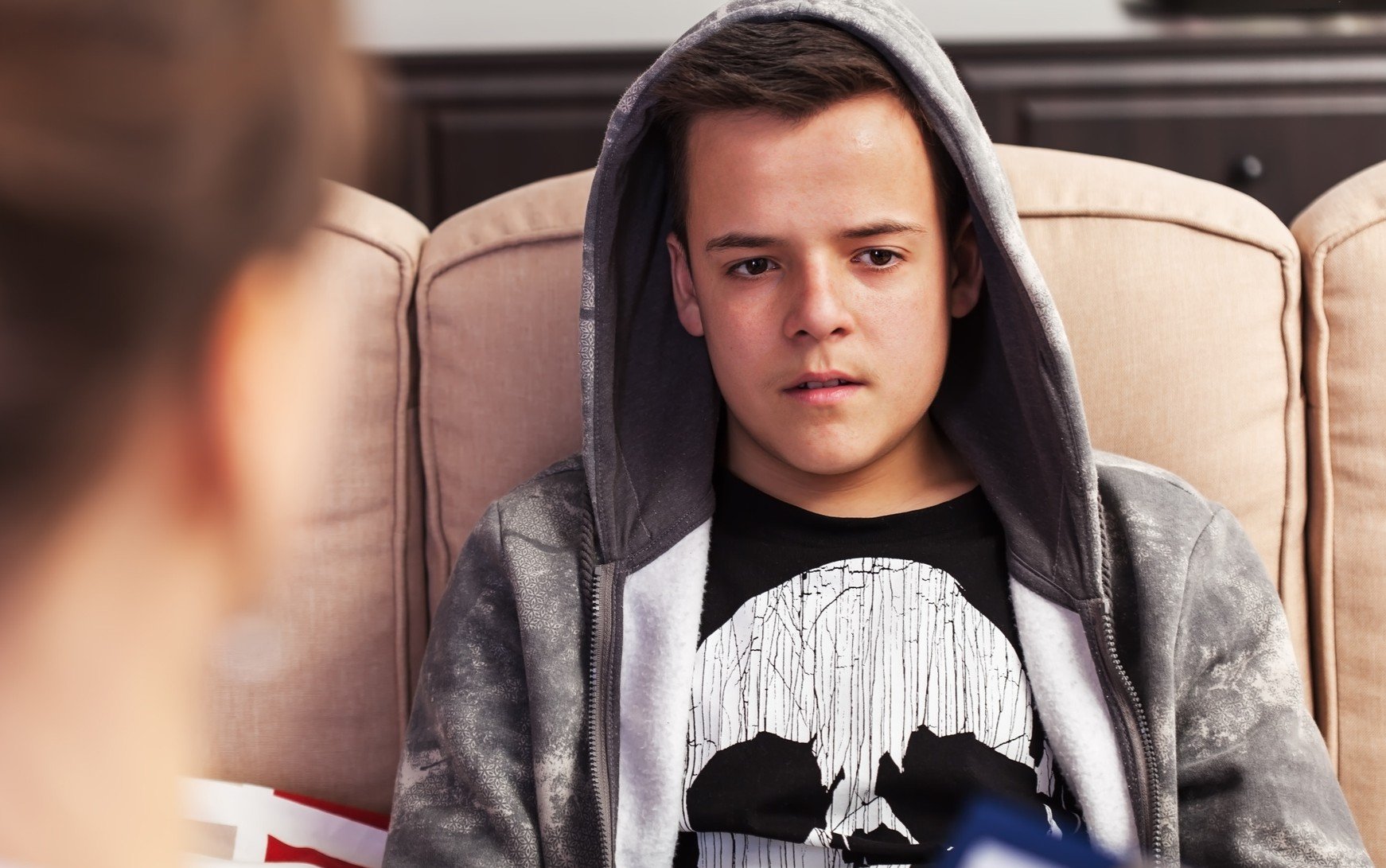 Bilde av en ungdom som sitter å snakker med en person